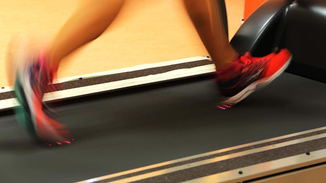 Pies de un atleta sobre una cinta de correr