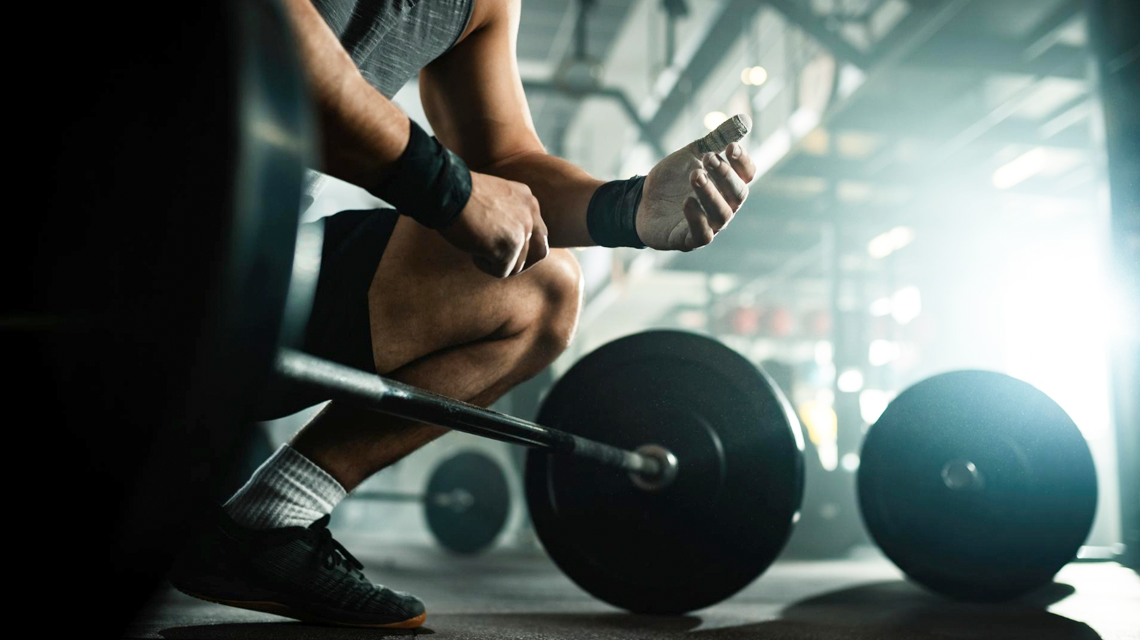 Imagen de un hombre con una pesa en un gimnasio